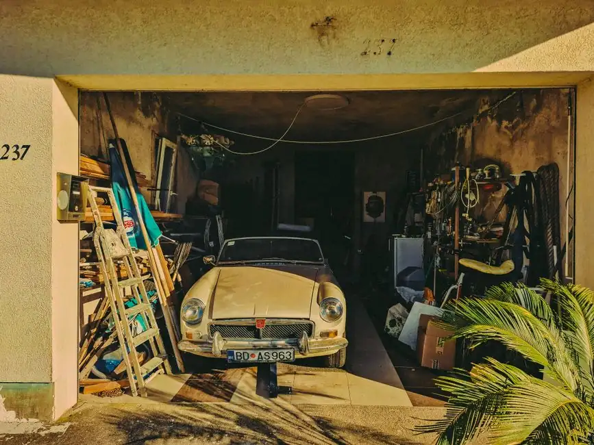 Classic convertible parked in a cluttered garage, Dobrota, Montenegro.