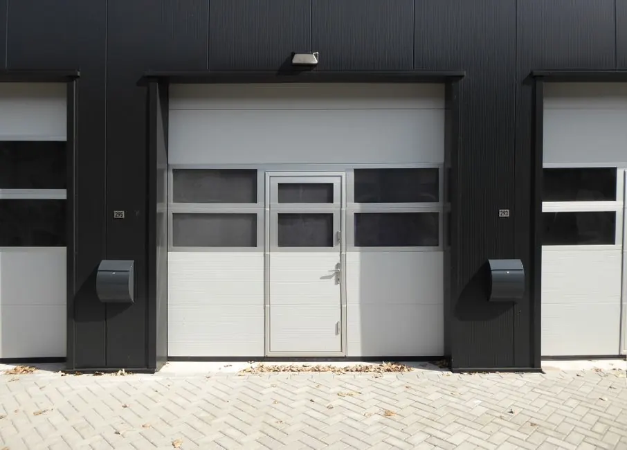 Modern industrial garage door with entrance, suitable for business property.